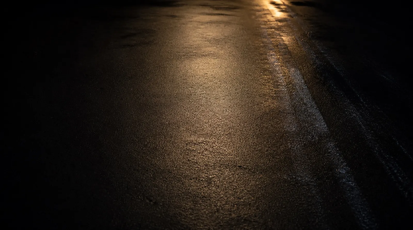 Wet street under a single light at night
