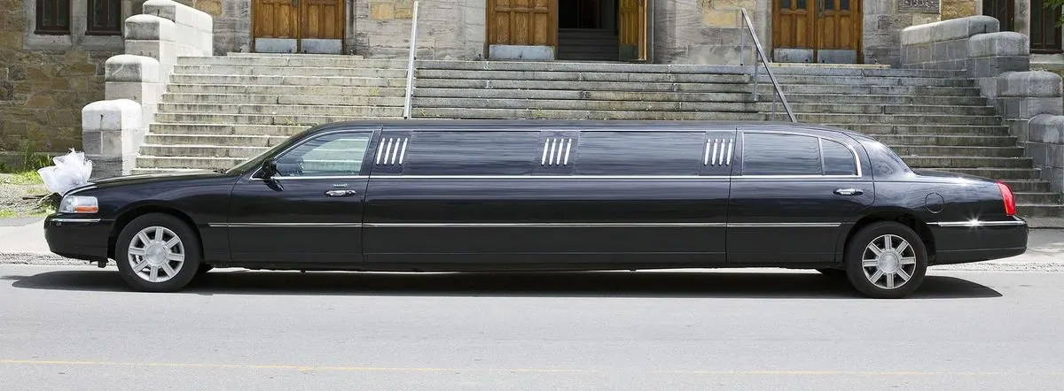 Black stretch limousine at the steps of a stone building